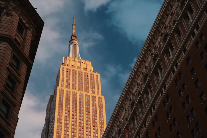 A skyscraper towers over two buildings in a city