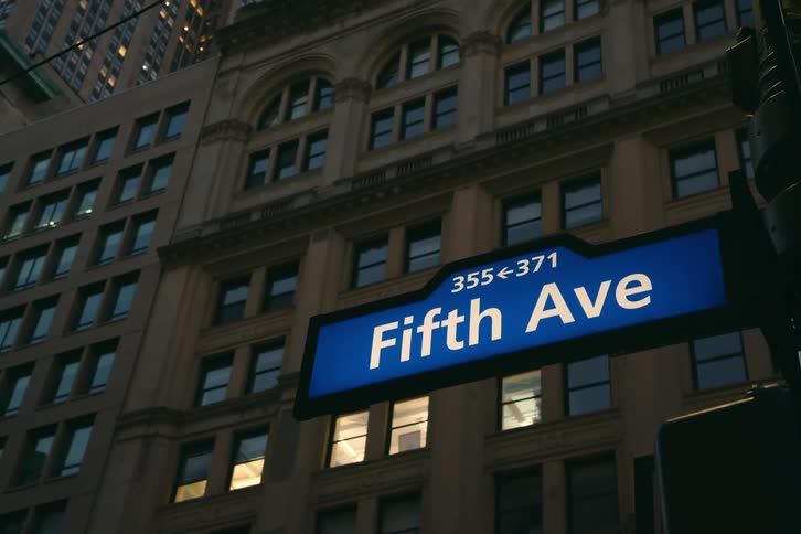 Close on an avenue sign with a building right behind