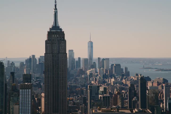 The empire state building dominates the cityscape towering over surrounding buildings
