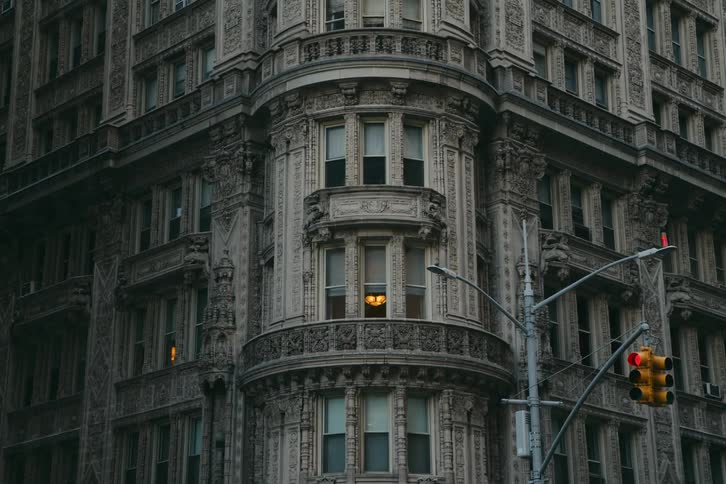 View of the facade of a building on an avenue with a red traffic light