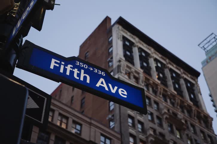 A street sign indicating fifth avenue in a corner of new york city