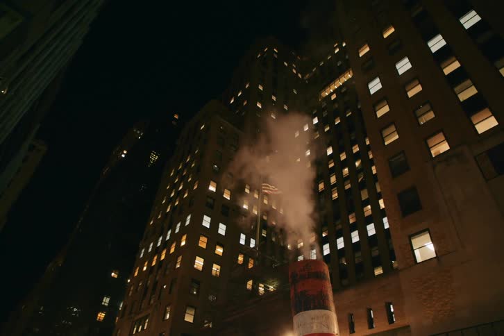A very tall building has multiple illuminated lights visible at night