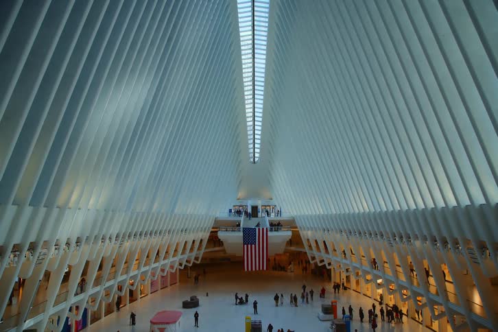 People wander through a large building with a skylight