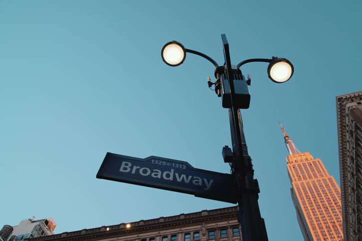 A street sign attached to the street lights pole at daytime