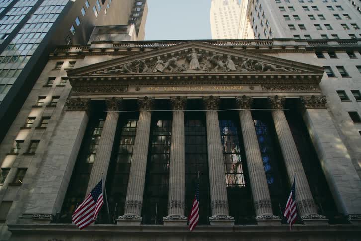 Upward view of buildings in a metropolis with the facade of the new york stock exchange