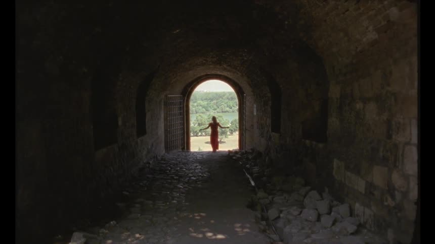 Vision of a stone tunnel with a woman on her back wearing a red dress