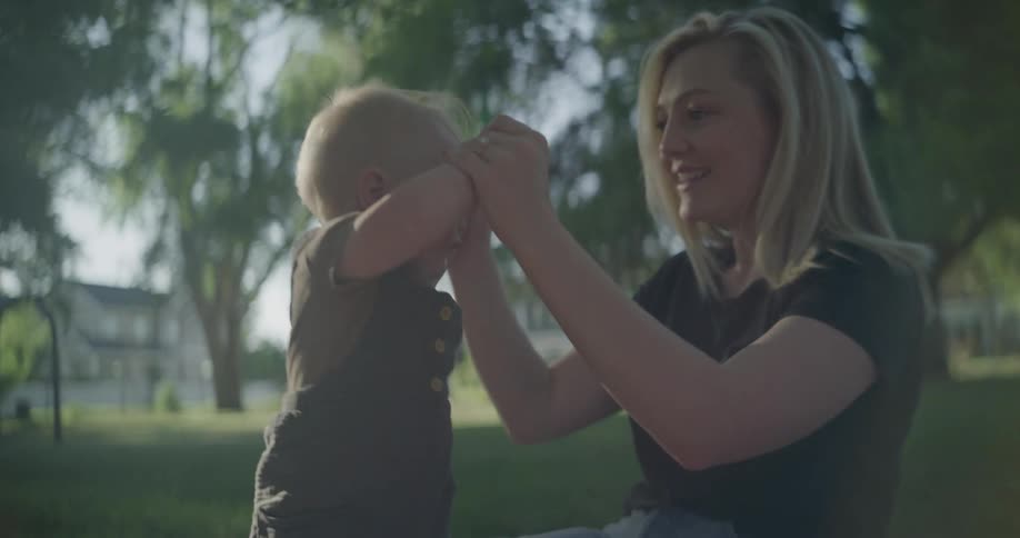 A mother and her baby play in the park