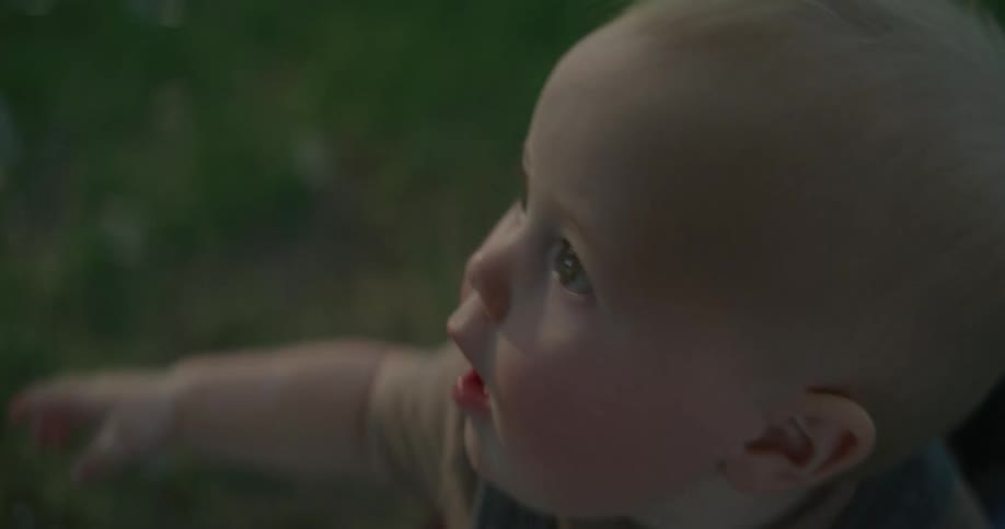 Closeup of a babys face playing in the grass