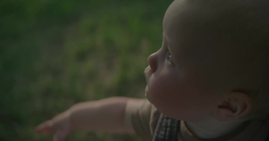 A baby watches soap bubbles floating in the open air