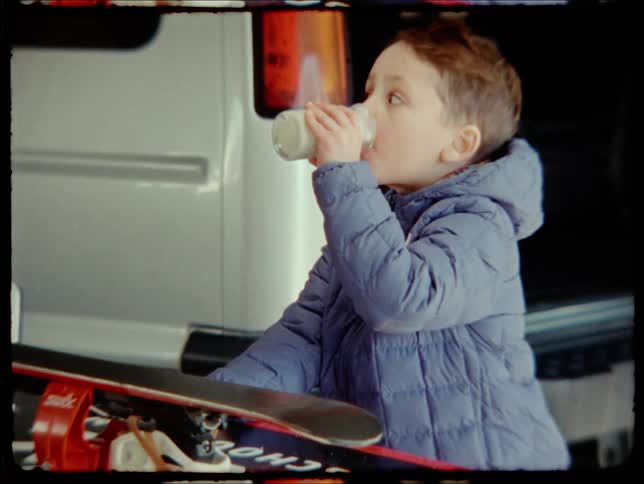 Little boy in the garage drinking milk