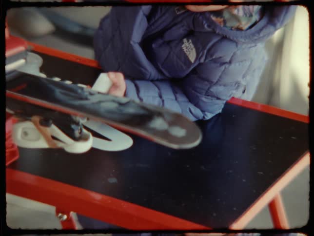 A child ironing a hot iron on a cutting board