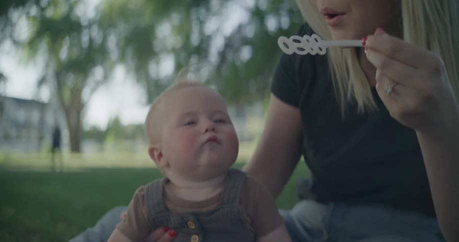 A woman playing with her baby while sitting on the floor