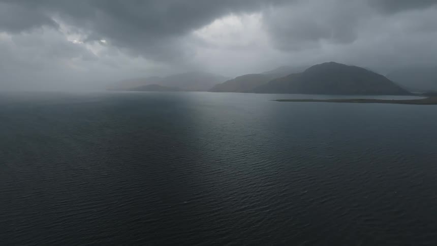 Dark clouds hang over mountians along the coast