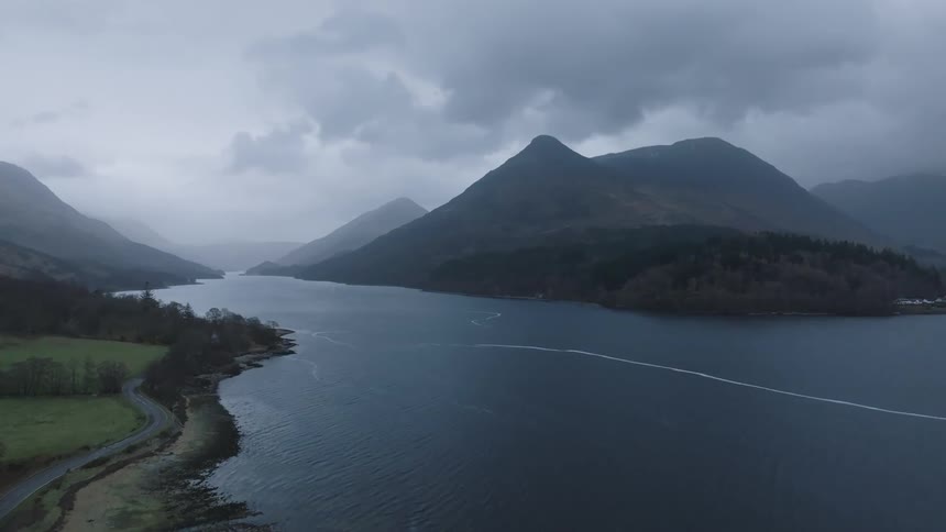 Several mountains are present on the shores around a large body of water