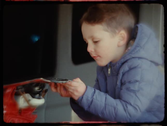 Side portrait of a little boy working a manual machine