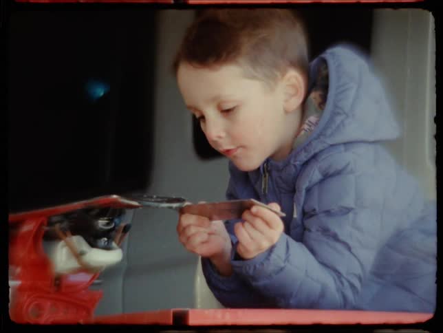 Boy playing with a tool on a workbench in the garage