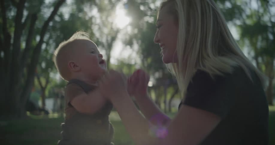 Mother playing with her baby in a garden