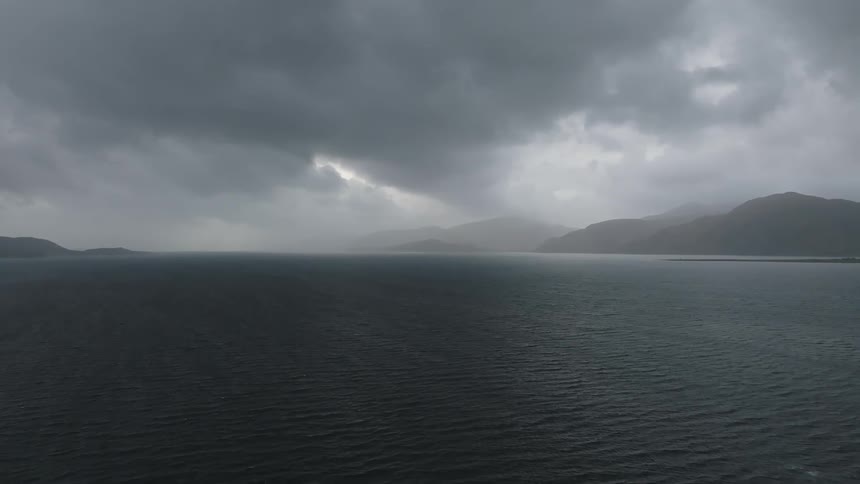 A placid sea under heavy storm clouds