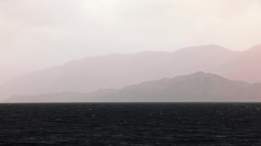 Time lapse of the moving sea and mountains on the horizon