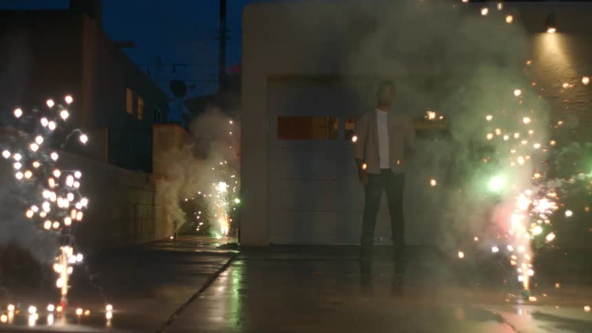Man outdoors at night and fireworks around him