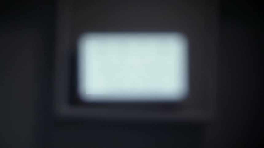 A wall monitor with a letter based eye test gets blurry