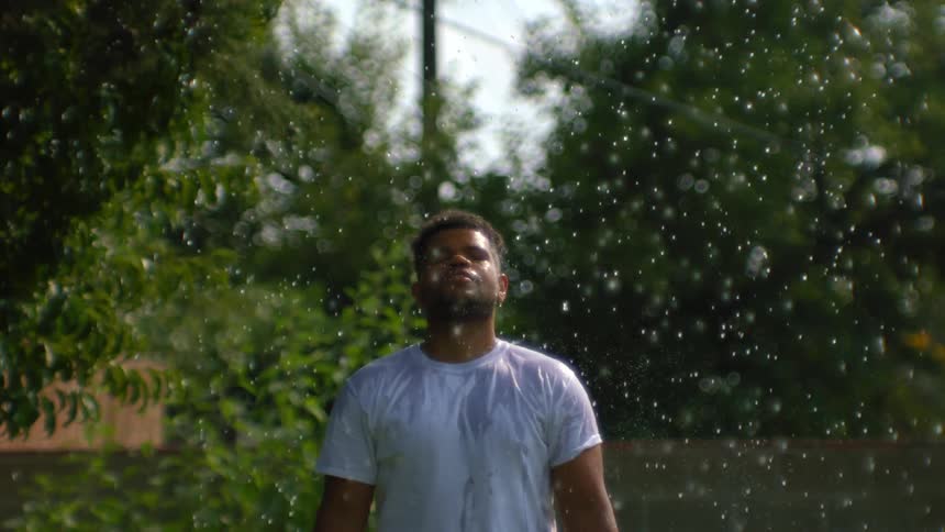Man with eyes closed in the rain getting wet