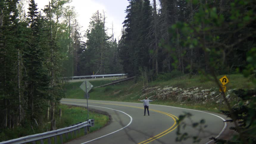 A man is standing in the middle of the road