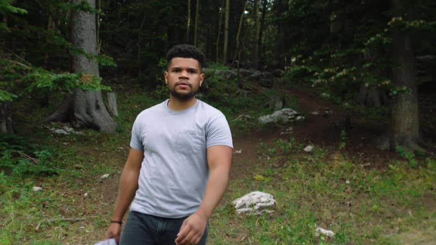 A man walks in the forest during the day
