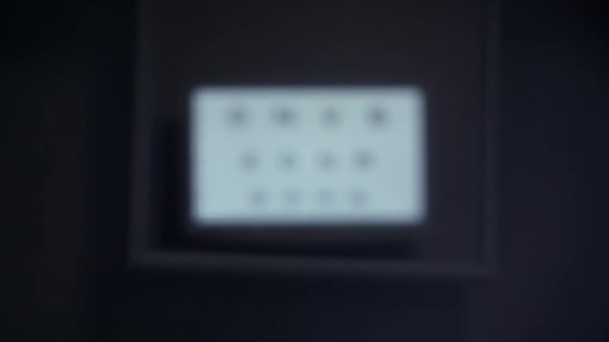 A digital screen shows an eye chart with three lines of letters