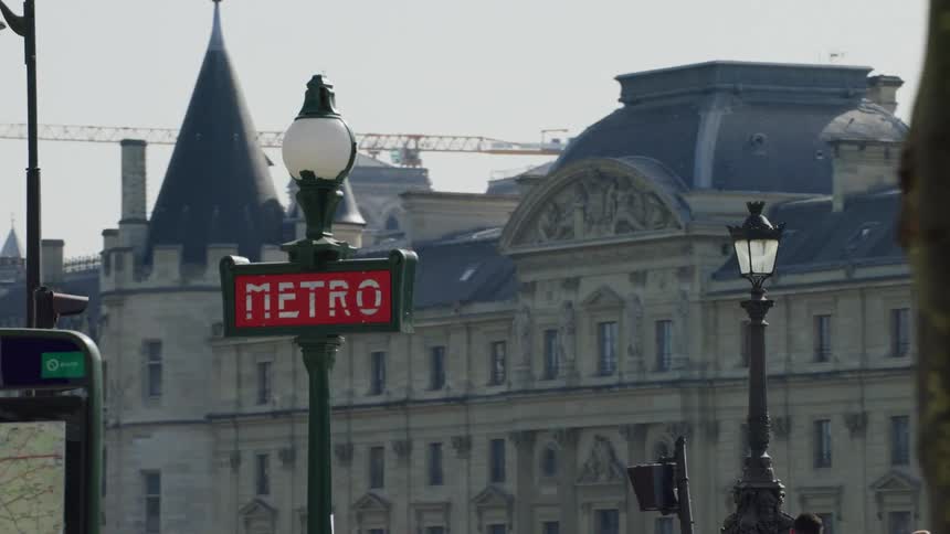 A parisian street with a prominent red metro sign