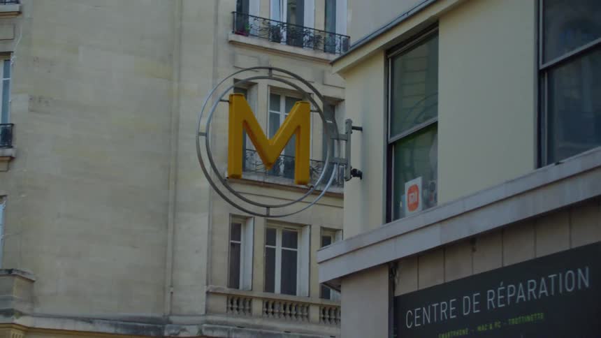 A classic european building with a yellow m sign on its exterior