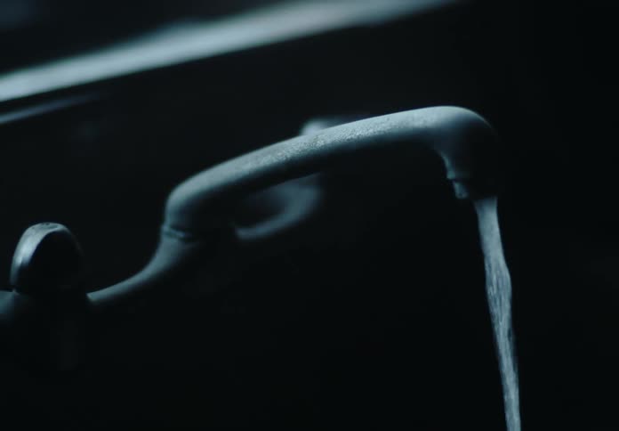 Closeup of a mans hand turning on and off a sink faucet