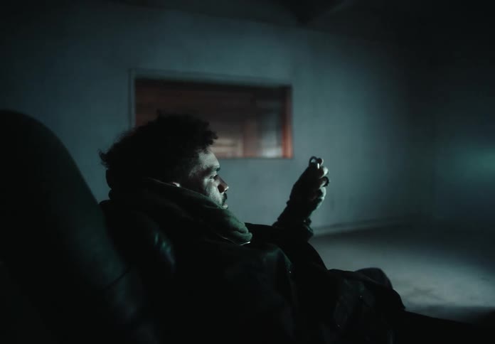 Man lying in an armchair inside an empty room