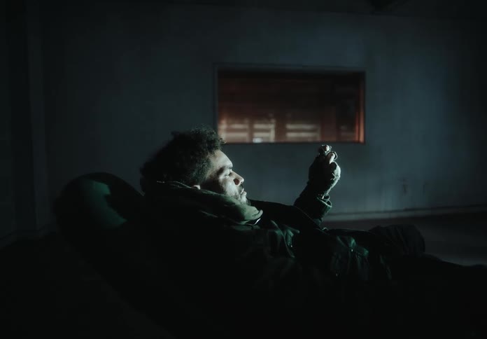 Man sitting in an armchair inside an empty room