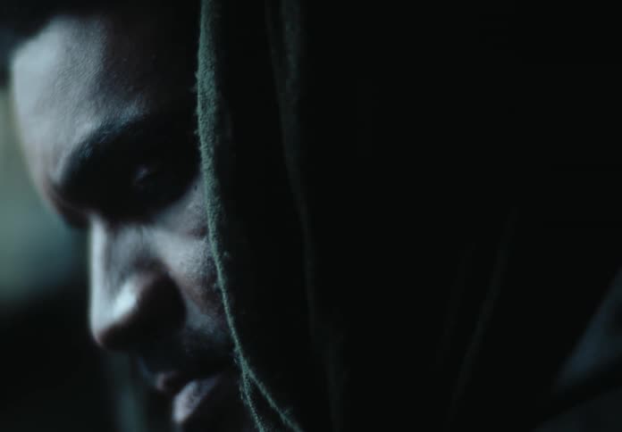 Closeup of a mans face with a hood over his head