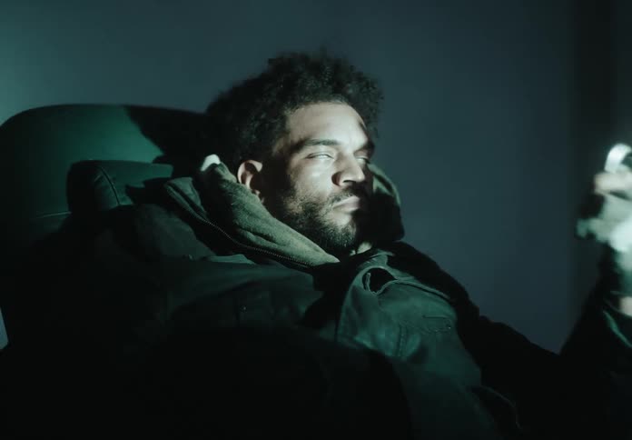 Man sitting in an armchair looks at an object in his hand and becomes hypnotized sleeping