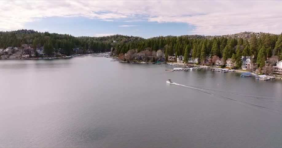 A boat on a calm lake with docks on the shore
