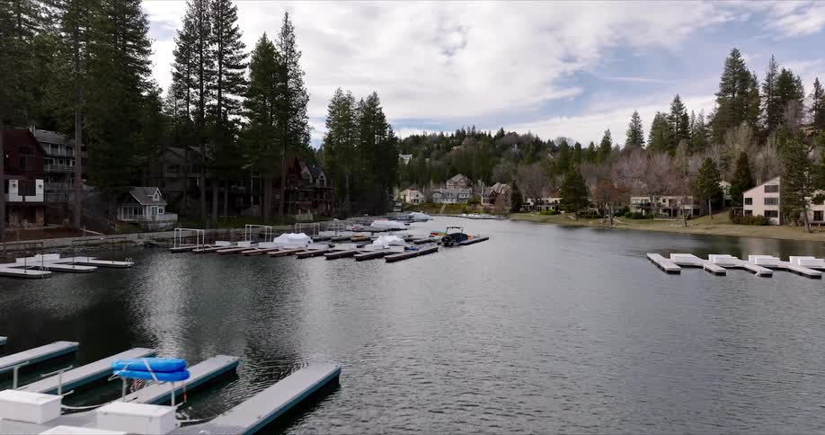 Docks with boats covered for the fall cluster along a riverbank lined with large homes and trees