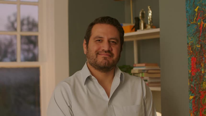 A man smiling while standing in a room