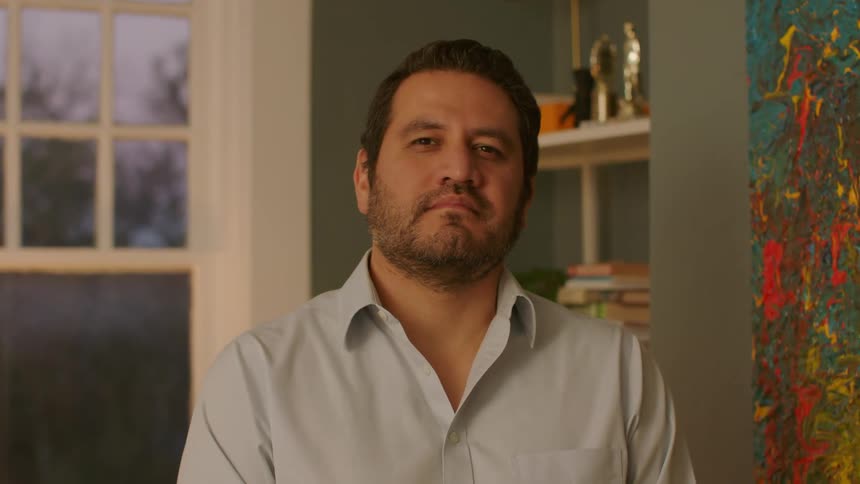 Face of a man seated in a room at sunset