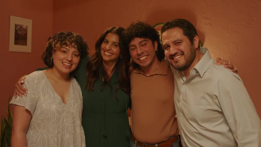 Four people are happy and posing for a photo while smiling