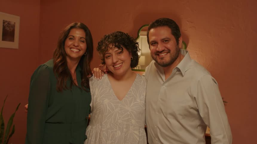 A portrait of parents and their daughter smiling