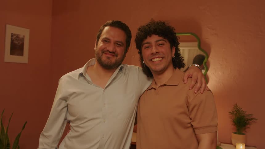 A father hugging his son as they smile together