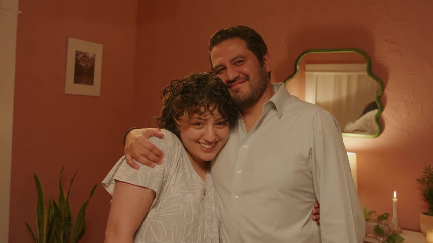 A father hugging his daughter as they smile at camera