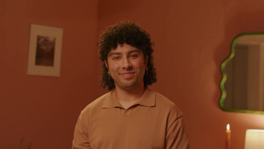 A smiling man with curly hair stood in the room
