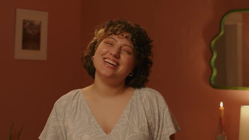 Happy woman with curly hair laughs and smiles for the camera