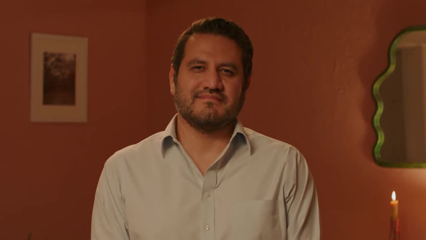 A man turns his face away while in the living room