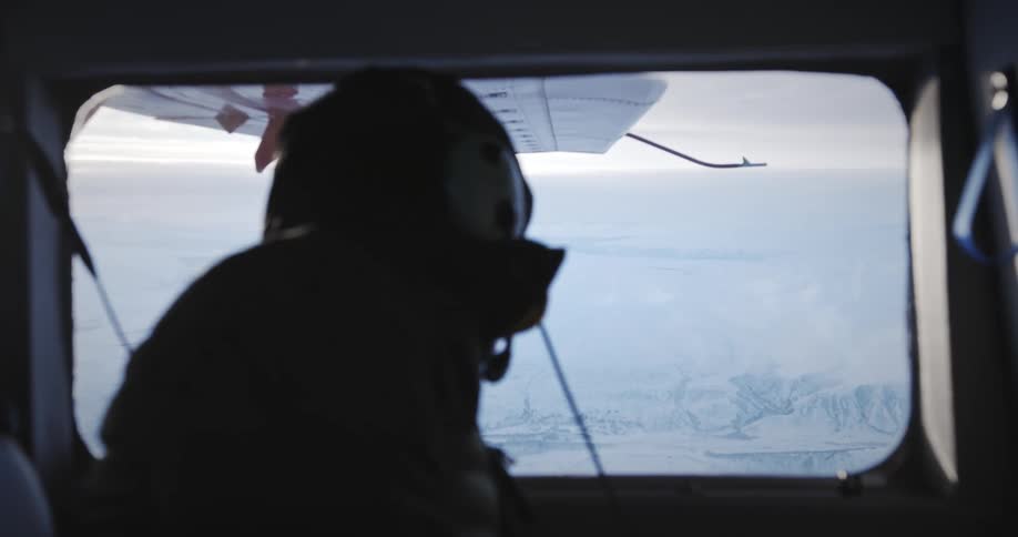 A man is looking out the plane window