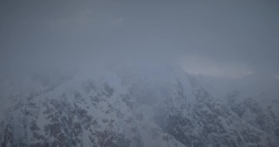 Aerial view of snowy mountain range in the clouds