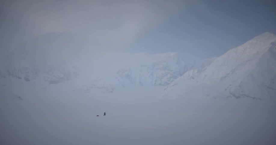 A person walking in a landscape of ice mountains during winter